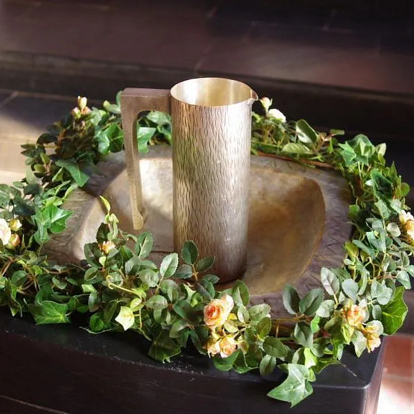 Geschmückter Taufstein mit Krug in der Martinskirche Cleverbrück.