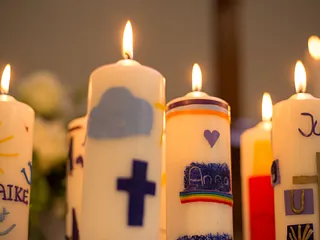 Brennende, von Konfirmand:innen bunt gestaltete Kerzen